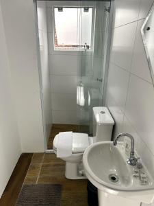 a white bathroom with a toilet and a sink at RCM Vilas - Casa Descolada in Joinville +15 photos