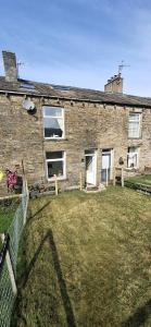 a brick house with a yard in front of it at Lancaster Cottage in Hawes
