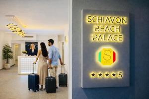 a man and woman walking with their luggage in a hotel at Schiavon Beach Palace in Lido di Jesolo +46 photos
