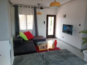 a living room with a couch and a glass table at TN Apartments deviat in Diani Beach