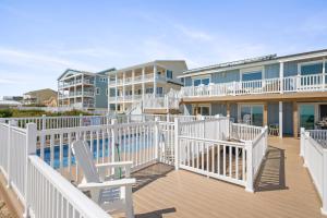 a deck with a chair and some condos at Carolina Clipper West by Emerald Isle Realty in Emerald Isle