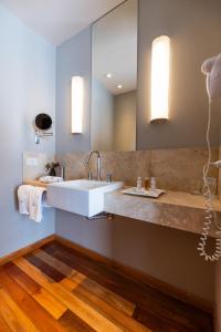 a bathroom with a white sink and two mirrors at Urban Suites Recoleta Boutique Hotel in Buenos Aires +102 photos