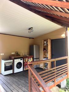 a kitchen with a deck with a washer and dryer at Moana Lodge in Raiatea