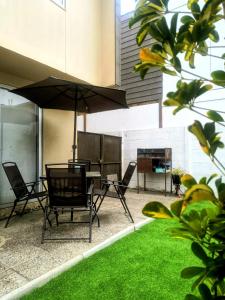 a patio with a table and chairs and an umbrella at CHEZ GERARDo ! in La Serena