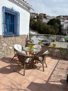 a patio with a table and chairs and a stone wall at La casita de Denis in Periana +37 photos