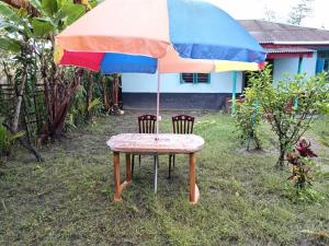 a table and two chairs under an umbrella at Bonolota Eco Villa in Mongla +5 photos