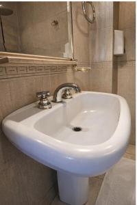 a white sink in a bathroom with a mirror at El Paso departamentos in San Juan +13 photos