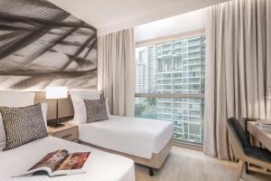 新加坡Ascott Orchard Singapore的有两张床和一扇窗户的酒店房间