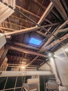 a room with a ceiling with wooden beams and chairs at Las Ventanas del Cielo, Ávila in Ávila +13 photos