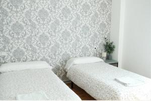 two beds in a bedroom with a wallpaper at BaruHaus GRUPOS Rua Legio in León +2 photos