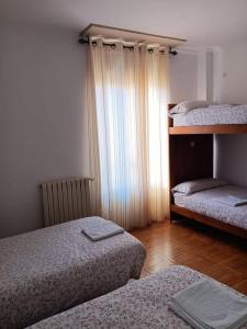 a bedroom with two twin beds and a window at BaruHaus GRUPOS Rua Legio in León