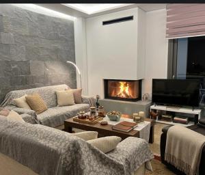 a living room with two couches and a fireplace at Anna's sea view apartment in Kánithos