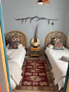 a bedroom with two beds and a table with a fan at La casita de Denis in Periana
