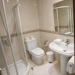 a bathroom with a toilet and a shower and a sink at PENSION LUCERNA in Vigo