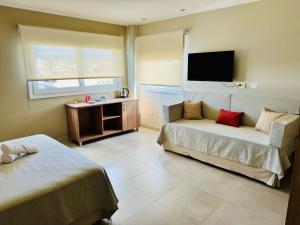 a hotel room with two beds and a flat screen tv at Terra Alta Suites in Salta