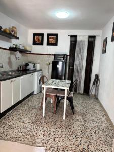 a kitchen with a table and a refrigerator at La casita de Denis in Periana