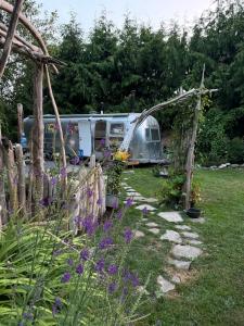 a caravan parked in a yard with a fence and flowers at Stay and Spa in Sooke