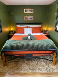 ein Schlafzimmer mit einem großen Bett und grünen Wänden in der Unterkunft Karinya Tiny House in Moogerah