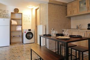 a kitchen with two tables and a white refrigerator at X N Skiathos in Skiathos