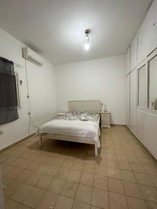 a white room with a bed and a television at Cringe Boutique APT in Netanya