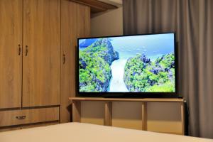 a flat screen tv sitting on a stand in a bedroom at X N Skiathos in Skiathos
