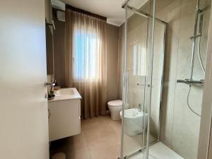 a bathroom with a shower and a toilet and a sink at LA TERRAZZA APARTMENTS - Sand & Green Apartments - DeltadelPo in Porto Viro +27 photos