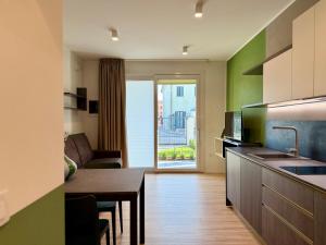 a kitchen with a table and a living room at LA TERRAZZA APARTMENTS - Sand & Green Apartments - DeltadelPo in Porto Viro