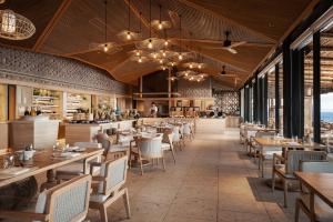 a restaurant with wooden ceilings and tables and chairs at Conrad Koh Samui in Taling Ngam Beach