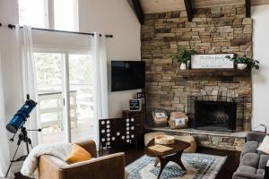 a living room with a stone fireplace and a couch at Little Chip Lake Arrowhead Cabin in Lake Arrowhead