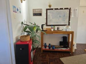 a room with a desk with a plant and a table at Akainij in Puerto Williams +5 photos