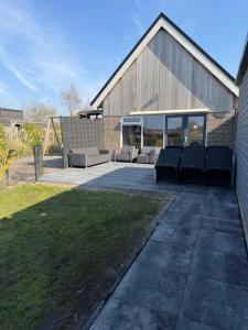 a patio with couches and chairs in front of a building at Hubanet in Giethoorn
