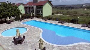 a pool at a resort with chairs and a building at Flat em Gravatá - Villa Monte Castelo in Sairé +27 photos