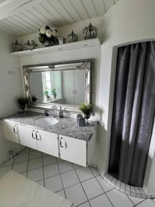 a bathroom with a sink and a mirror at Romantisk bondehus in Strandby +8 photos