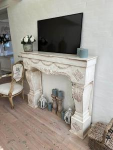 a white fireplace with a television on top of it at Romantisk bondehus in Strandby