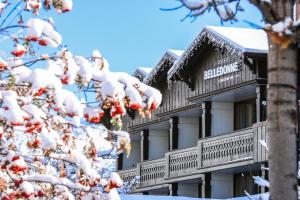 ein schneebedecktes Gebäude neben einem Baum in der Unterkunft La Résidence Belledonne in Courchevel