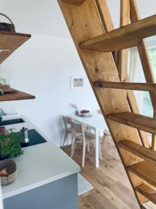 a kitchen with a table and a wooden stairway at Skrzydła Biebrzy- Eco Cottage nad rzeką Narwią - Biebrza NP in Niwkowo