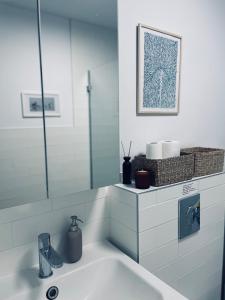 a white bathroom with a sink and a mirror at Skrzydła Biebrzy- Eco Cottage nad rzeką Narwią - Biebrza NP in Niwkowo