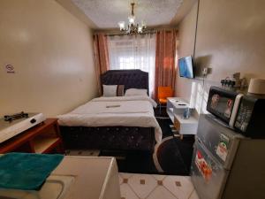 a small room with a bed and a refrigerator at Goodlife Studio - NRS Kinoo in Rungiri +35 photos