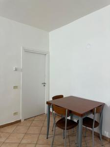 a table and chairs in a room with a door at Spazioso appartamento 2 in Tortona