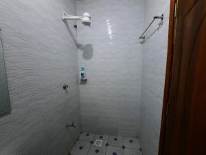 a white bathroom with a shower with a toilet at Goodlife Studio - NRS Kinoo in Rungiri