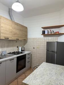 a kitchen with a stove and a refrigerator at Spazioso appartamento 2 in Tortona