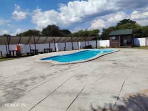 an empty swimming pool with a building in the background at Oluhle Resort in Hammanskraal
