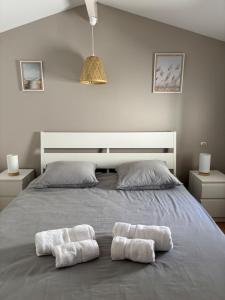 a bedroom with two towels on a bed at Maison avec plage à pied in Saint-Georges-dʼOléron