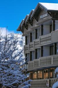 a hotel in the snow with a mountain in the background at La Résidence Belledonne in Courchevel