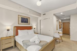 a bedroom with a bed with white sheets and pillows at Luxury Studio Steps from Bayfrontpark in Miami +18 photos