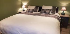 a bedroom with a large white bed with two lamps at Central House in Shillelagh