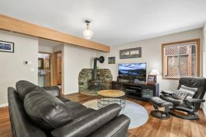 a living room with a leather couch and chairs at River Rock House-Deck-BBQ-Forest Trails & Views! in South Lake Tahoe +40 photos