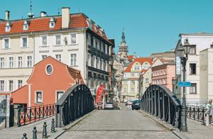 a bridge over a street in a city with buildings at Złote Apartamenty Kłodzko in Kłodzko