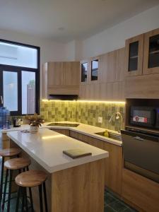 a kitchen with wooden cabinets and a counter with stools at Tata Van in Ấp Sung Xuân