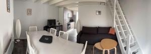 a living room with a staircase and a couch at Maison avec plage à pied in Saint-Georges-dʼOléron